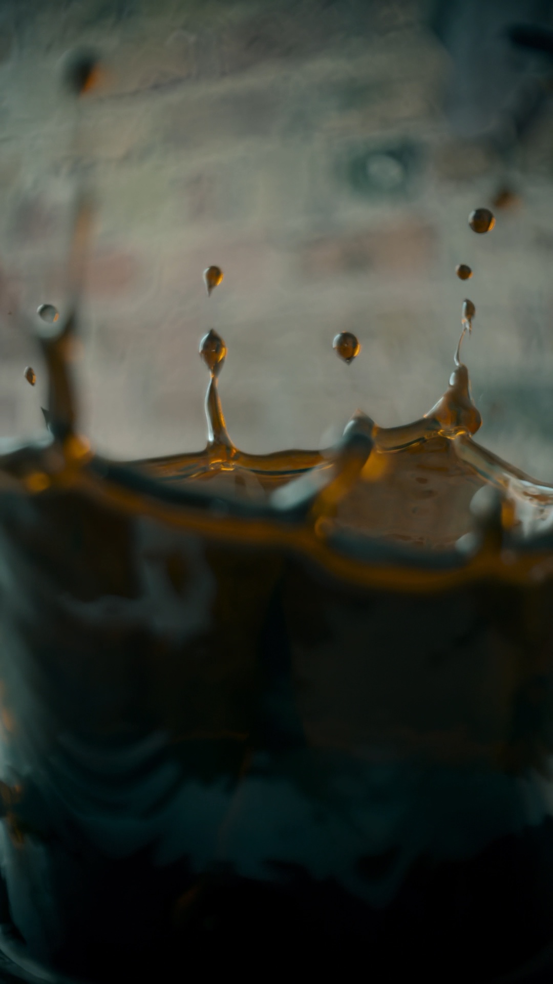 Close-up of a crown splash simulation: dark liquid rising at the rim and breaking into individual droplets