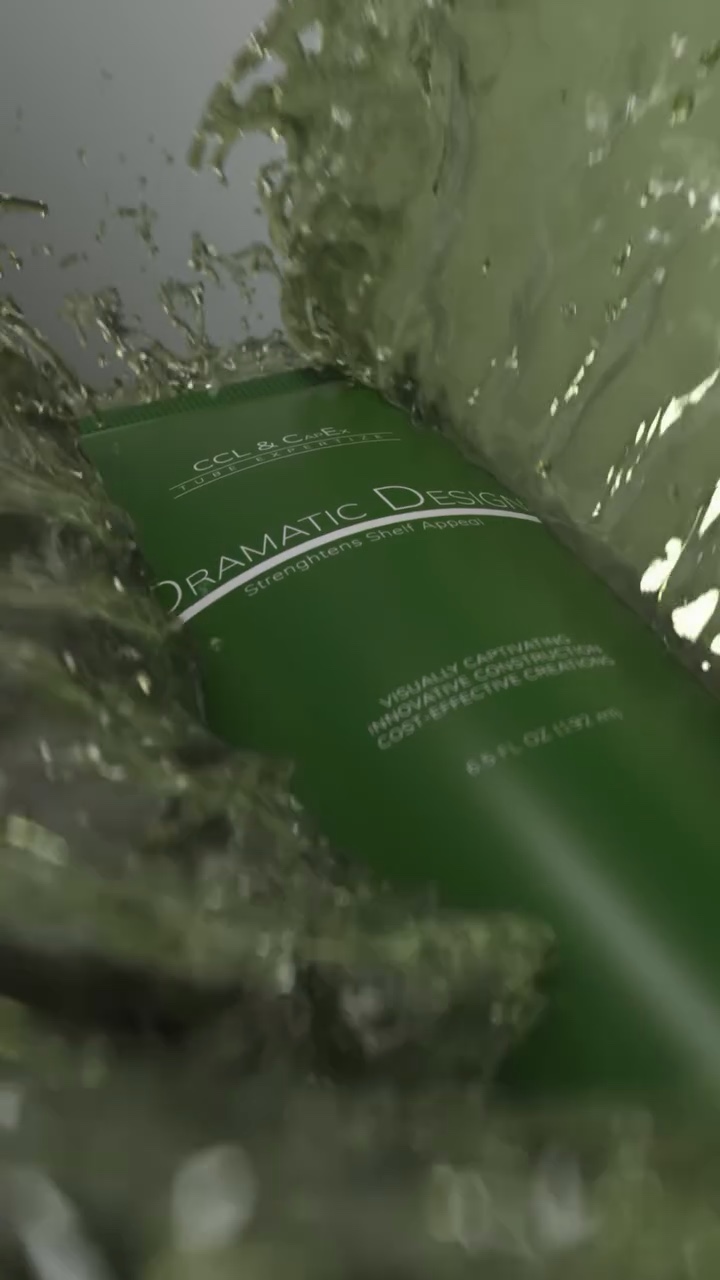 Green cosmetics tube at an angle, washed over by a wave of green liquid